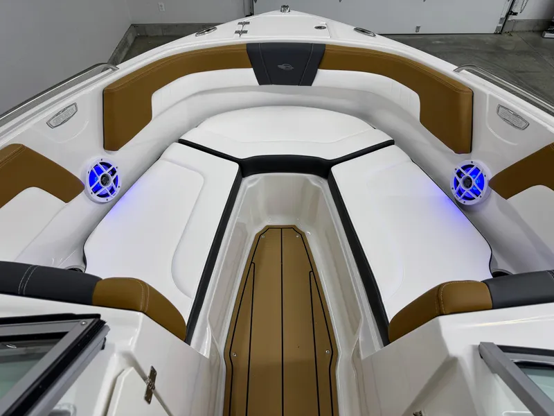 Slide: The Image of 2025 Chaparral 23 SSi boat interior with cushioned seating and blue LED speakers. - 32