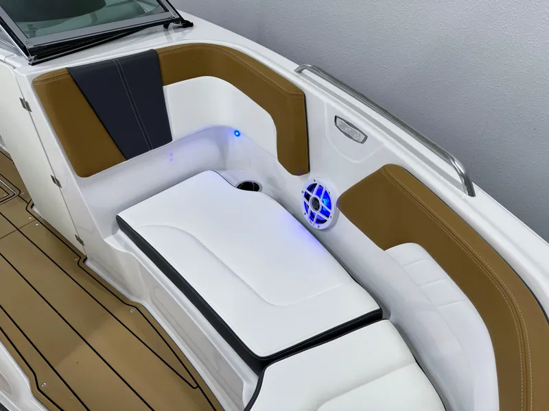 Slide: The Image of 2025 Chaparral 23 SSi boat interior with brown and white seating, blue LED lighting. - 33