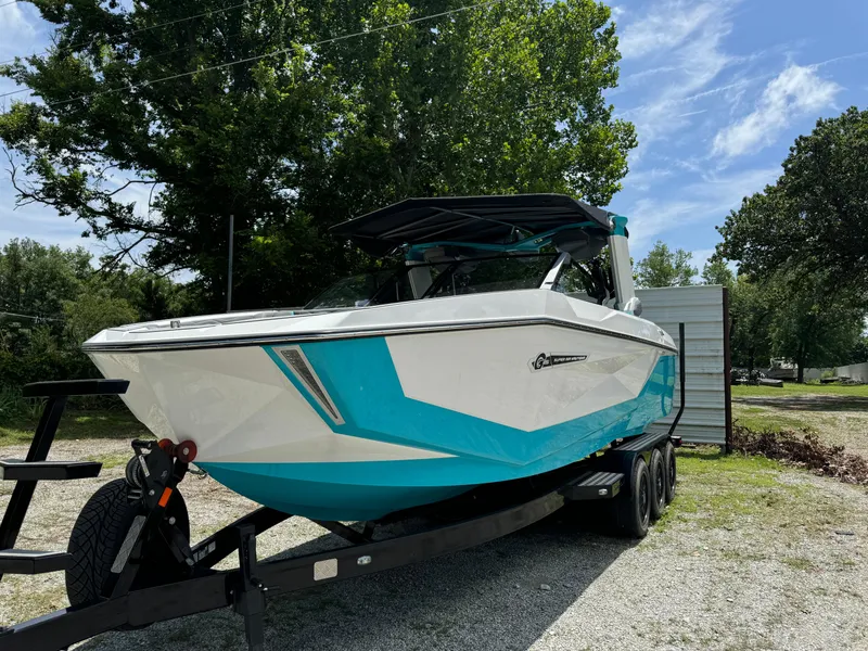 Slide: The Image of 2025 Nautique G25 boat on trailer, parked outdoors under clear sky. - 7