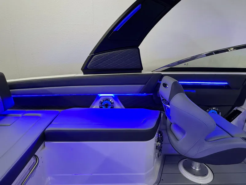 Slide: The Image of 2025 Chaparral 26 Surf boat interior with blue LED lighting and modern seating. - 23