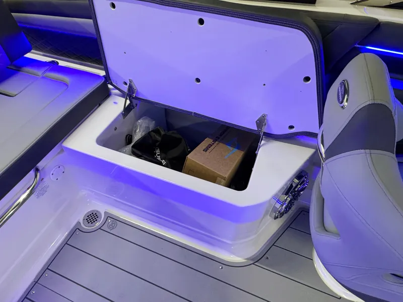Slide: The Image of 2025 Chaparral 26 Surf boat storage compartment with blue LED lighting. - 24