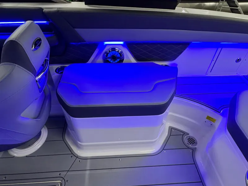 Slide: The Image of 2025 Chaparral 26 Surf boat interior with blue LED lighting and cushioned seating. - 27