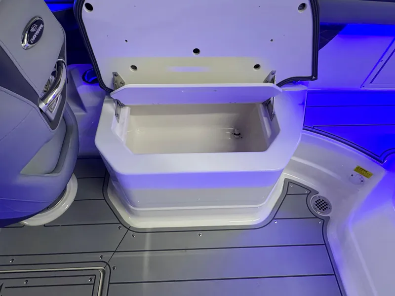 Slide: The Image of 2025 Chaparral 26 Surf boat interior with open storage compartment and blue LED lighting. - 29
