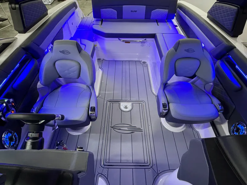 Slide: The Image of 2025 Chaparral 26 Surf boat interior with blue LED lighting and modern seating. - 30