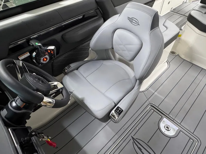 Slide: The Image of 2025 Chaparral 26 Surf boat interior with sleek captain's chair and modern controls. - 44