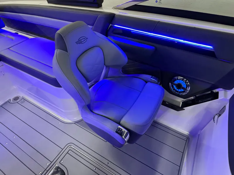 Slide: The Image of 2025 Chaparral 26 Surf boat interior with blue LED lighting and modern seating. - 49