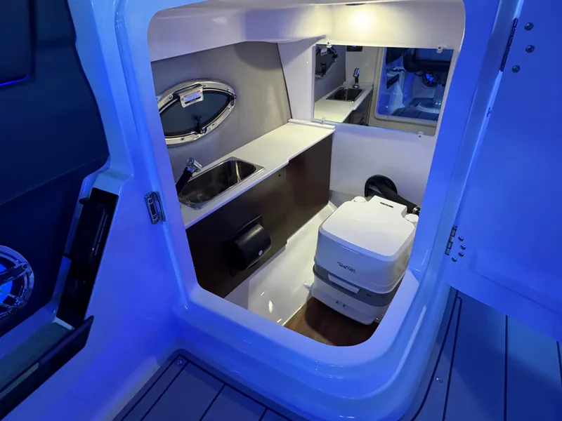 Slide: The Image of Interior of 2025 Chaparral 26 Surf boat with compact bathroom amenities. - 52