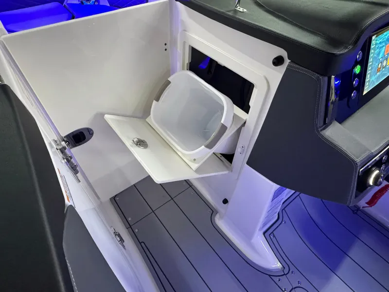 Slide: The Image of 2025 Chaparral 26 Surf boat interior with storage compartment and modern dashboard. - 54