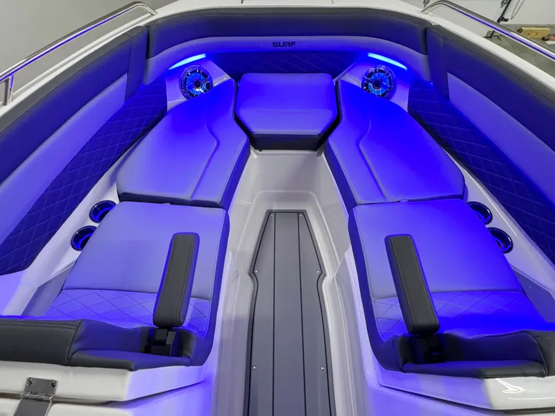 Slide: The Image of 2025 Chaparral 26 Surf boat interior with blue LED lighting and luxurious seating. - 56