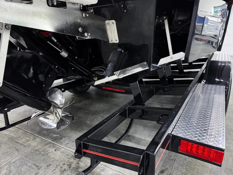 Slide: The Image of 2025 Chaparral 26 Surf boat on trailer, showcasing propeller and rear details. - 6