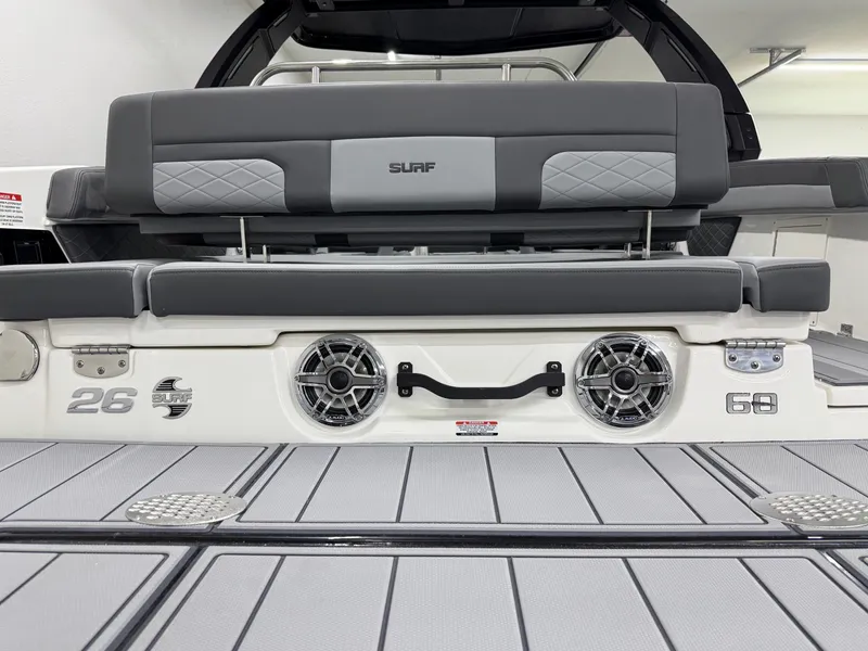Slide: The Image of 2025 Chaparral 26 Surf boat interior with gray seating and speakers. - 8