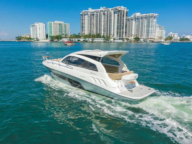 Slide: The Image of 2025 Hanover 375 Outboard cruising near modern waterfront buildings. - 4