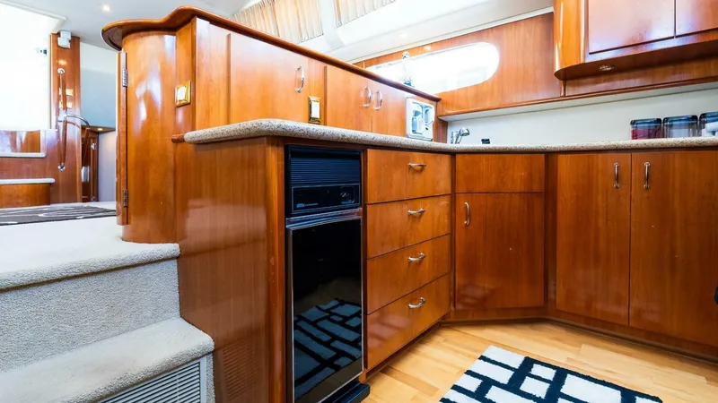 Slide: The Image of Interior of 2004 Carver 466 Motor Yacht with wooden cabinetry and modern kitchen amenities. - 16