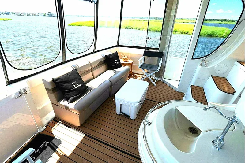 Slide: The Image of 2004 Carver 466 Motor Yacht interior with sofa, sink, and scenic water view. - 5