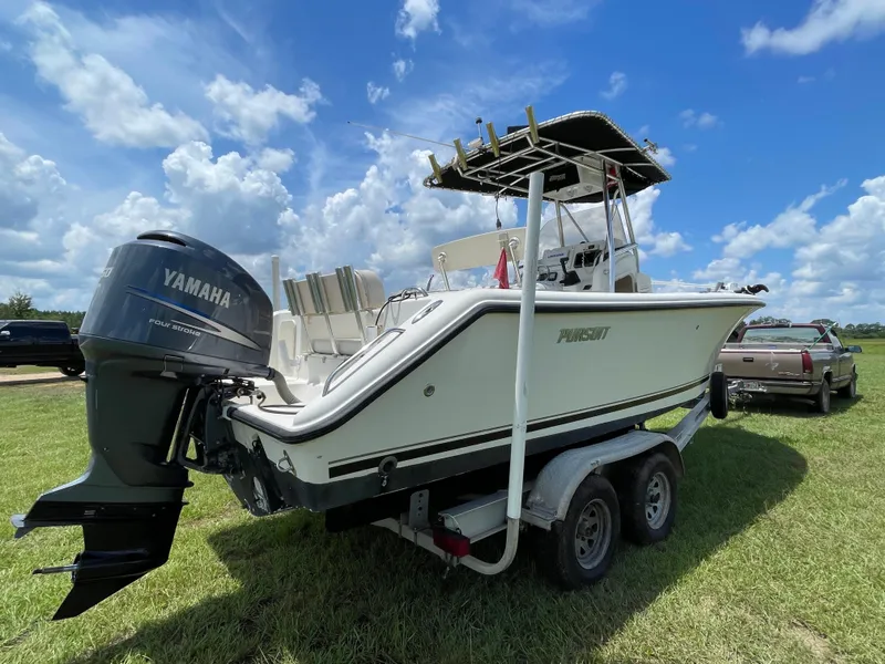 Slide: The Image of 2008 Pursuit 230 Center Console boat on trailer with Yamaha outboard motor, under blue sky. - 1