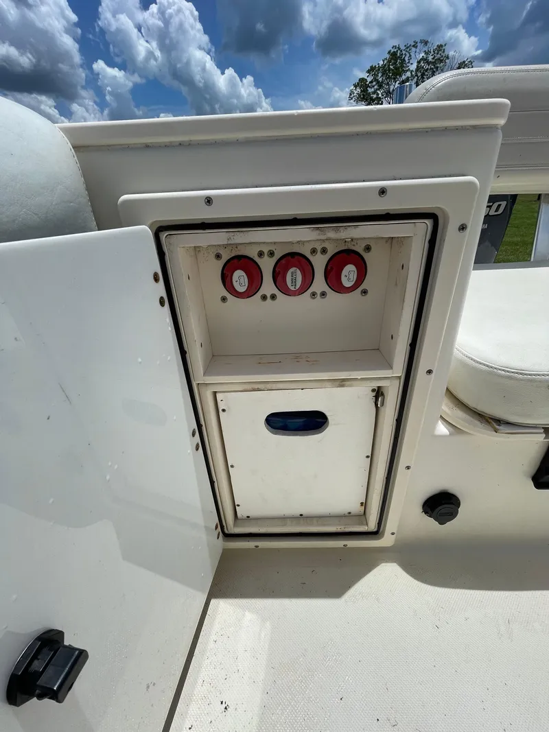 Slide: The Image of 2008 Pursuit 230 Center Console boat storage compartment with control panel. - 12