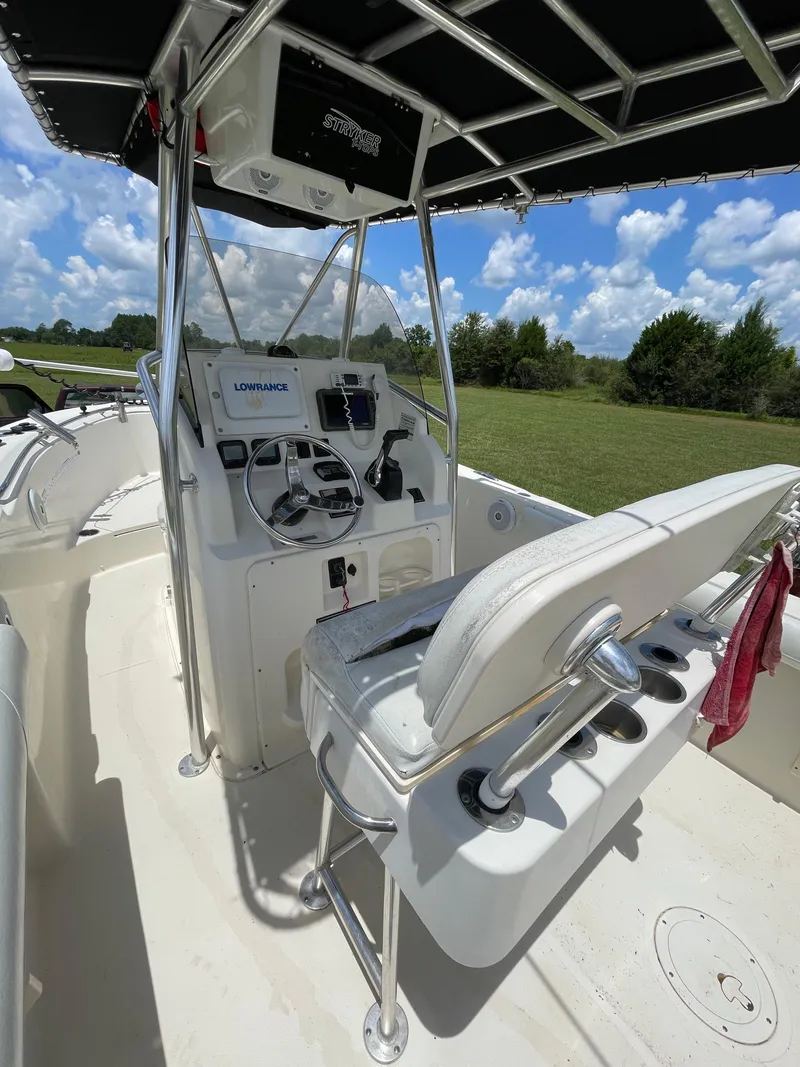 Slide: The Image of 2008 Pursuit 230 Center Console boat with steering console and seating, under a clear blue sky. - 13
