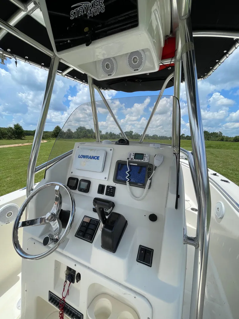 Slide: The Image of 2008 Pursuit 230 Center Console boat dashboard with navigation equipment under a clear sky. - 14