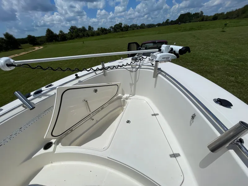 Slide: The Image of 2008 Pursuit 230 Center Console boat with open storage compartment on grassy field. - 22