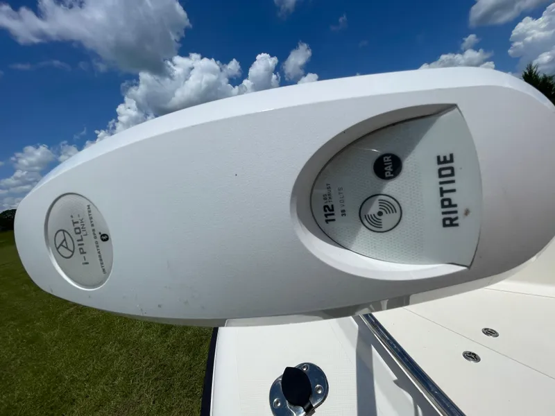 Slide: The Image of Minn Kota Riptide trolling motor on 2008 Pursuit 230 Center Console boat under blue sky. - 24