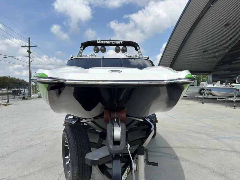 Slide: The Image of 2014 MasterCraft X2 boat on trailer, parked outdoors under a partly cloudy sky. - 11