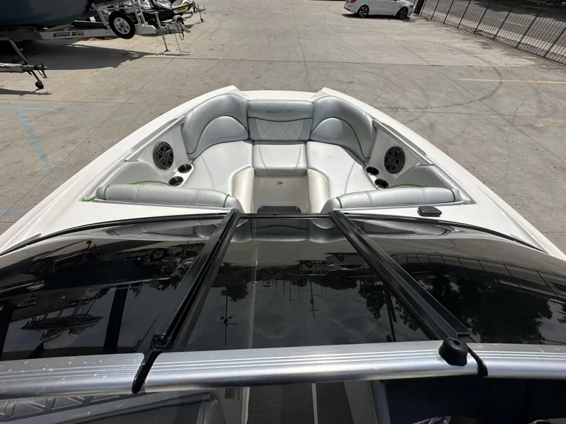 Slide: The Image of 2014 MasterCraft X2 boat interior with white seating and speakers, parked on concrete. - 14