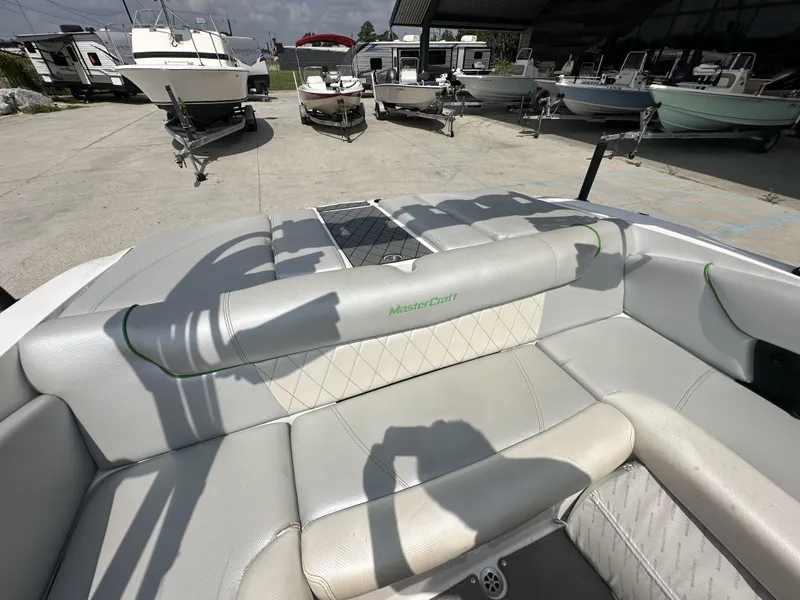 Slide: The Image of 2014 MasterCraft X2 boat interior with white seating, parked among other boats. - 15