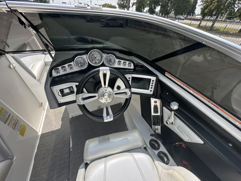 Slide: The Image of 2014 MasterCraft X2 boat cockpit with steering wheel, gauges, and control panel. - 9