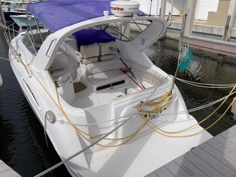 Slide: The Image of 1999 Bayliner Cierra 3055 boat docked with purple canopy and white seating. - 3