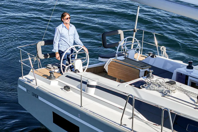 Slide: The Image of 2024 Bavaria C38 yacht on water, person steering, sunny day. - 23