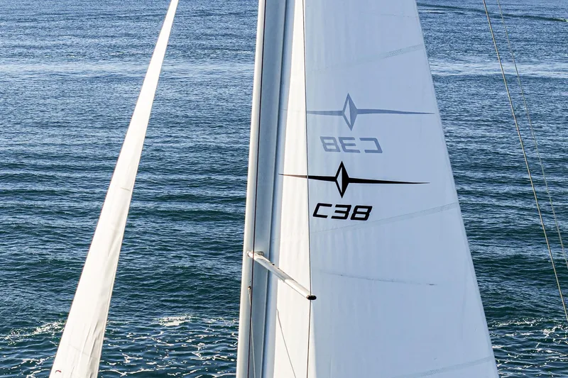Slide: The Image of 2024 Bavaria C38 sailboat on open water, showcasing sleek sails and ocean backdrop. - 24