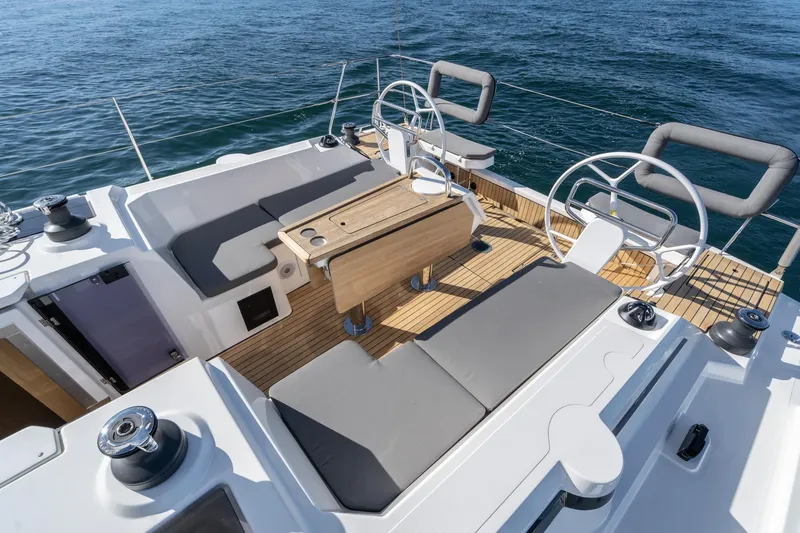 Slide: The Image of 2024 Bavaria C38 yacht deck with dual steering wheels and seating area. - 37