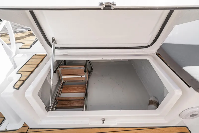 Slide: The Image of 2024 Bavaria C38 yacht storage compartment with wooden steps and open hatch. - 39