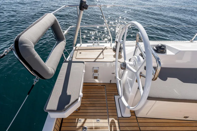 Slide: The Image of 2024 Bavaria C38 yacht helm with wooden deck and cushioned seating. - 42