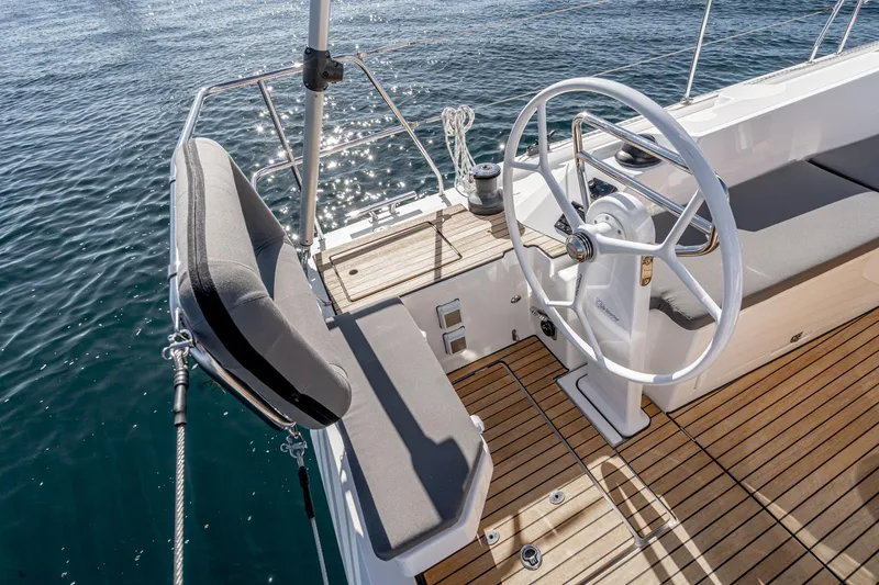 Slide: The Image of 2024 Bavaria C38 yacht helm with wooden deck and cushioned seating. - 43