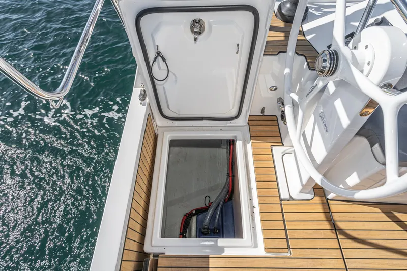Slide: The Image of 2024 Bavaria C38 yacht deck with open hatch, revealing storage compartment. - 44