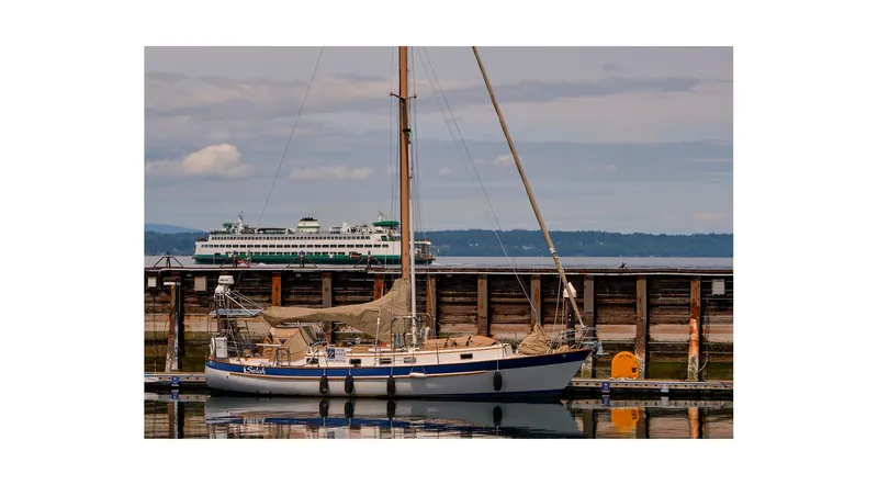 Slide: The Image of 1983 Valiant 40 Selah sailboat docked with ferry in background. - 1