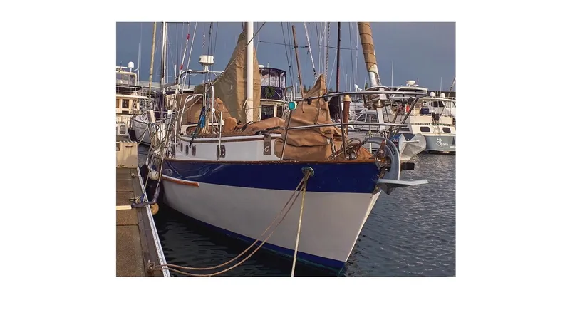 Slide: The Image of 1983 Valiant 40 Selah sailboat docked in a marina, surrounded by other boats. - 114