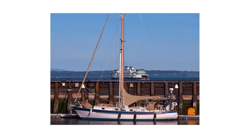 Slide: The Image of 1983 Valiant 40 Selah sailboat docked with ferry in background. - 154