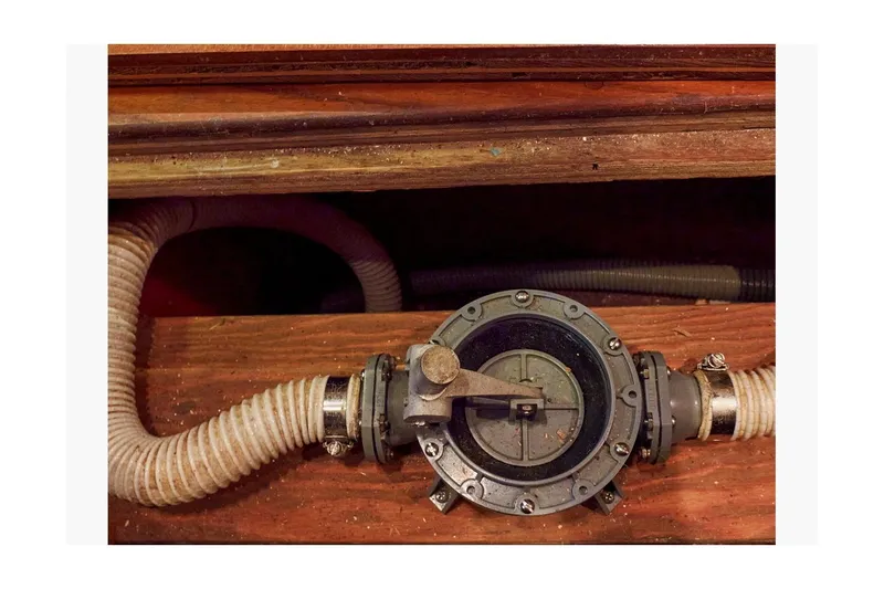 Slide: The Image of 1983 Valiant 40 Selah boat bilge pump with hoses in wooden compartment. - 28