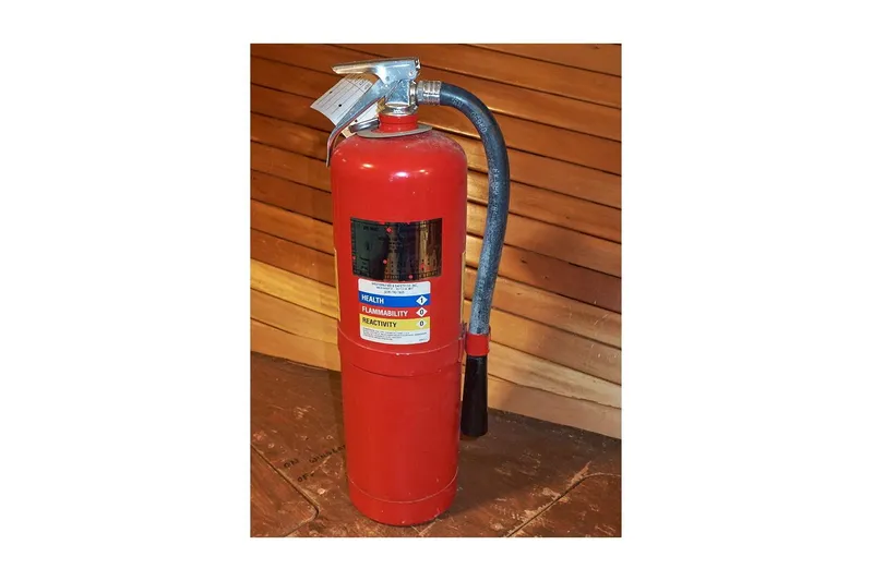 Slide: The Image of Red fire extinguisher with hose, wooden background, Valiant 40 Selah, 1983 model. - 40