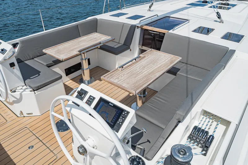 Slide: The Image of 2024 Bavaria C50 yacht deck with seating, tables, and navigation controls. - 34