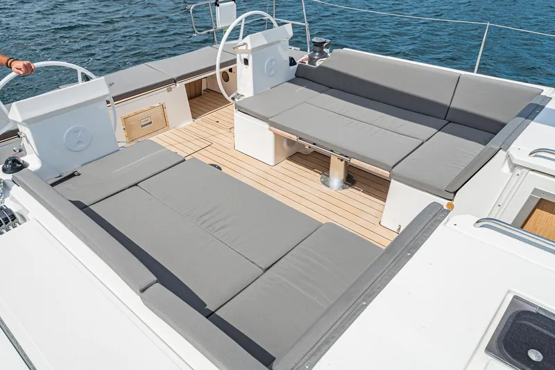 Slide: The Image of 2024 Bavaria C50 yacht deck with gray seating and wooden flooring. - 40