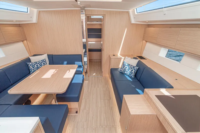 Slide: The Image of 2024 Bavaria C50 yacht interior with modern wood finish and blue seating. - 45