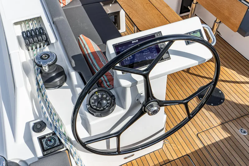 Slide: The Image of 2024 Bavaria C45 yacht helm with steering wheel, compass, and navigation controls. - 31