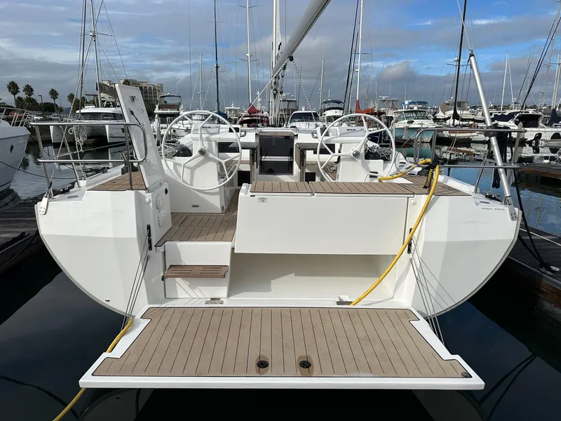 Slide: The Image of 2024 Bavaria C45 yacht docked at marina, showcasing dual steering wheels and spacious deck. - 4
