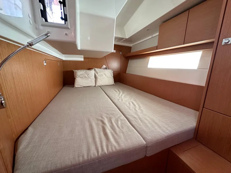 Slide: The Image of 2024 Bavaria C45 yacht cabin with cozy double bed and modern wood finish. - 42