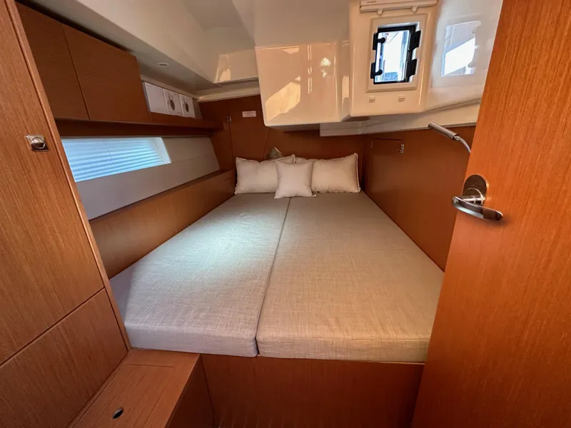 Slide: The Image of 2024 Bavaria C45 yacht cabin with cozy double bed and wooden interior. - 47