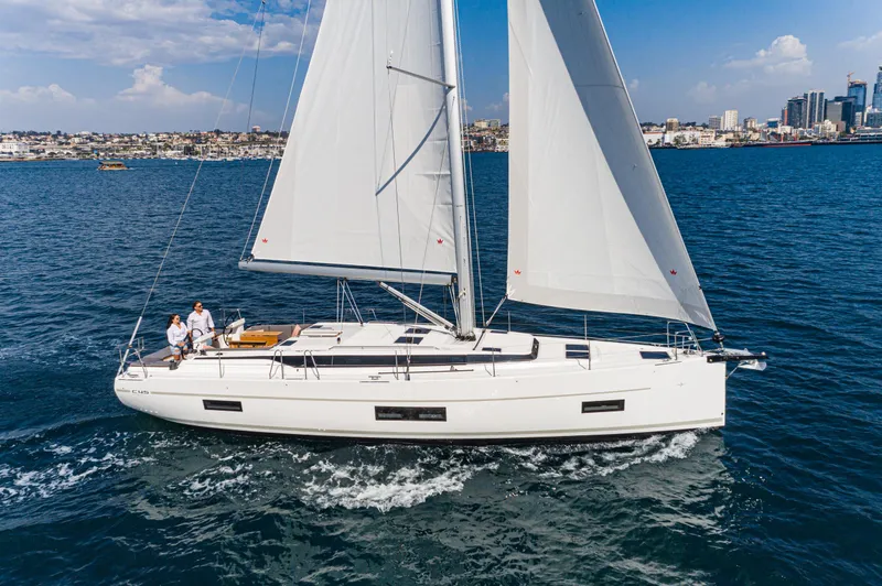 Slide: The Image of 2024 Bavaria C45 sailing yacht on open water, city skyline in background. - 7