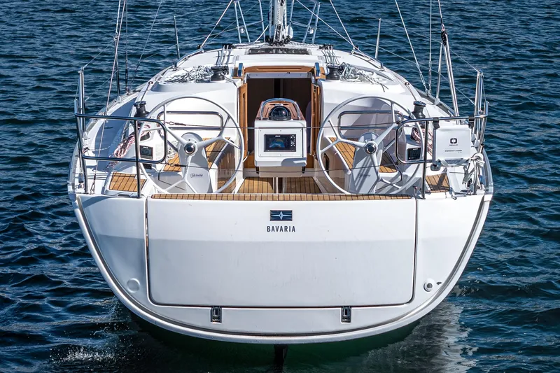Slide: The Image of 2024 Bavaria Cruiser 34 yacht on water, rear view, showcasing dual steering wheels. - 11